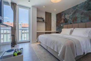 a bedroom with a large bed and a large window at Petit Palace in Zadar