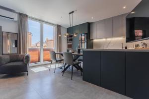 a kitchen and dining room with a table and chairs at Petit Palace in Zadar