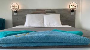 ein Bett mit einer blauen Decke darüber in der Unterkunft Rêve Bleu 711 Marinotel in Le Diamant