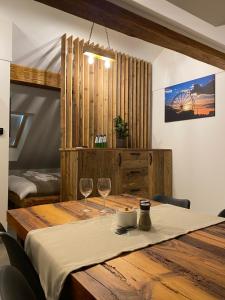 a wooden table with two wine glasses on it at Apartamenty Zander in Zator