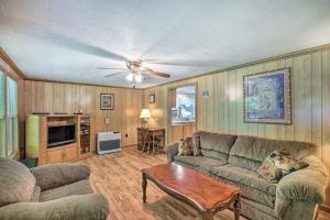 a living room with a couch and a table at Charming Cabin Retreat Creek Access On-Site! in Hot Springs