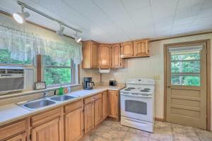 a kitchen with wooden cabinets and a white stove top oven at Charming Cabin Retreat Creek Access On-Site! in Hot Springs