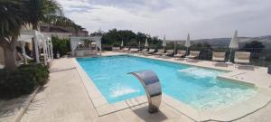 a large swimming pool with lounge chairs around it at Anthos Casa Vacanze in SantʼOmero