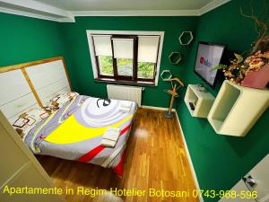 Dormitorio verde con cama y ventana en Apartament nemaipomenit de frumos Super accesibil, en Botoşani