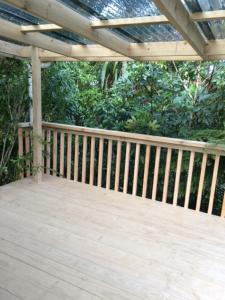 a wooden deck with a pergola and trees at Tui Glen in Raurimu Spiral