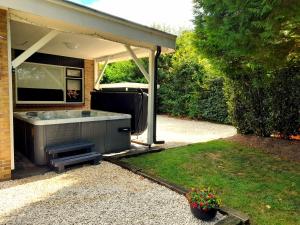 a backyard with a barbecue under a pavilion at Secret Wellness Oase in Holten