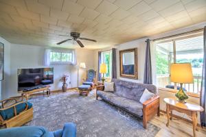 a living room with a couch and a tv at Cozy Ishpeming Cottage with Lake and Park Views! in Ishpeming