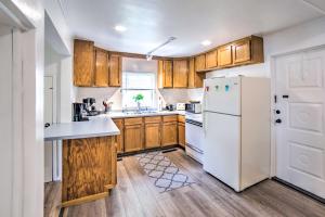 a kitchen with wooden cabinets and a white refrigerator at Cozy Ishpeming Cottage with Lake and Park Views! in Ishpeming