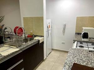 a kitchen with a sink and a refrigerator at Hermoso departamento,totalmente amoblado c/cochera in Salta