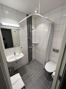 a bathroom with a shower toilet and a sink at Senja Living in Stonglandseidet +81 photos