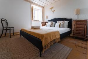 奧比多斯的住宿－Casa Amarela，一间卧室配有一张大床和一把椅子
