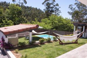um quintal com uma rede de descanso e uma piscina em Villa Luna em San Mamés de Meruelo