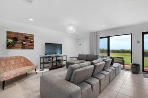 a living room with a couch and a tv at Capistrano 103 in Watersound Beach