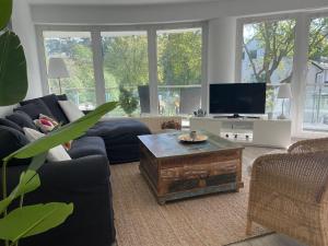 a living room with a blue couch and a tv at Strandhaus-Nordseebrandung-Fewo-A1-5 in Cuxhaven