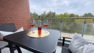 zwei Gläser Wein auf einem Tisch auf einem Balkon in der Unterkunft Strandhaus Nordseebrandung Fewo A3.3 in Cuxhaven