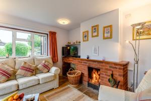 a living room with a couch and a fireplace at The Olde House in Upton Bishop