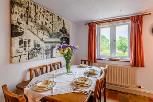 een eettafel met een vaas met bloemen erop bij The Olde House in Upton Bishop