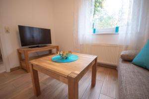 a living room with a coffee table and a flat screen tv at Haus-Kirsten-Fewo-Nr-1 in Cuxhaven