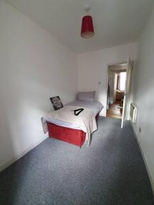 sypialnia z łóżkiem z czerwoną deską w obiekcie Lovely 2 bedroom flat in the heart of the city w Edynburgu