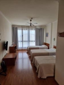 a hotel room with four beds and a ceiling fan at Hotel Avenida de Canarias in Vecindario