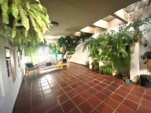 a living room with plants on the walls and a tile floor at Pousada Family Consulado Americano in São Paulo