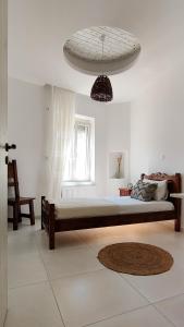Laina Traditional Guest House في Apérathos: غرفة نوم بسرير كبير ونافذة