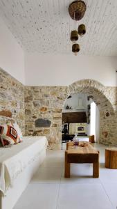 Laina Traditional Guest House في Apérathos: غرفة معيشة مع أريكة وطاولة