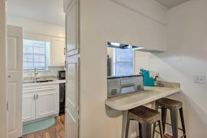 a kitchen with white cabinets and a counter with stools at Modern Jackson Townhome about 6 Mi to Downtown! in Jackson