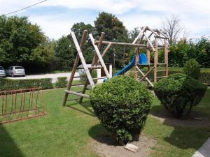 a wooden playground with a slide in a yard at Penzion Mala in Jarovce