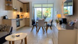 cocina y sala de estar con mesa y sillas en Haus Dortmund - Ferienwohnung Nr.2 en Cuxhaven
