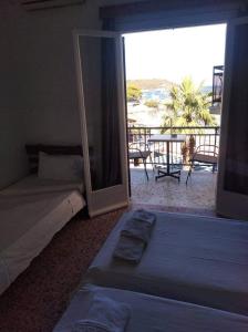 a bedroom with two beds and a view of the beach at Ammoudia Rooms in Agia Marina Aegina