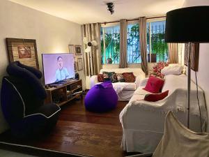 a living room with a couch and a tv at Family Hostel in Sao Paulo