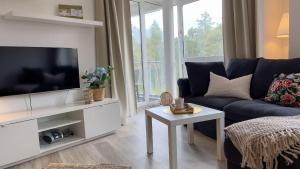 a living room with a blue couch and a tv at Strandhaus-Nordseebrandung-Fewo-B2-3 in Cuxhaven