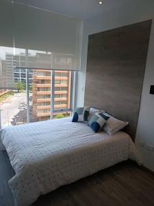 Schlafzimmer mit einem weißen Bett und einem großen Fenster in der Unterkunft Loft Moderno en Bogotá -Usaquén in Bogotá