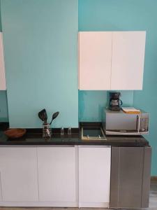eine Küche mit weißen Schränken und einer Mikrowelle in der Unterkunft Loft Moderno en Bogotá -Usaquén in Bogotá