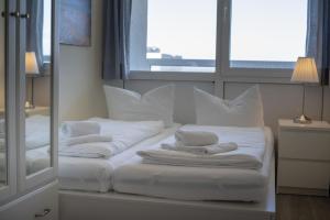 Habitación con 2 camas, almohadas blancas y espejo. en Frische-Brise-15-09, en Cuxhaven