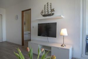 sala de estar con TV y mesa con lámpara. en Frische-Brise-15-09, en Cuxhaven