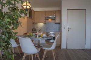 cocina con mesa y sillas blancas en Frische-Brise-15-09, en Cuxhaven