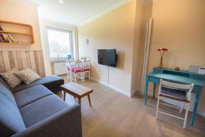 ein Wohnzimmer mit einem blauen Sofa und einem Tisch in der Unterkunft Haus Frauenpreiss - Ferienwohnung 57 in Cuxhaven
