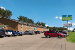 a parking lot with cars parked in front of a building at SureStay Hotel by Best Western Thomson in Thomson