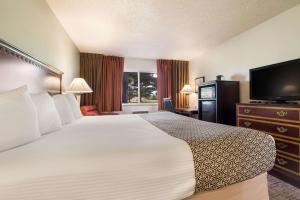 a hotel room with a bed and a flat screen tv at SureStay Hotel by Best Western Thomson in Thomson