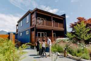 un grupo de personas parados frente a una casa en Pluvio restaurant and rooms, en Ucluelet