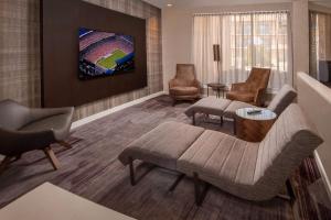 a living room with a couch and chairs and a tv at Sonesta Select Columbia in Columbia