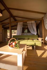 a bedroom with a bed and a basket of fruit on a table at Glamping Podere San Jacopo in Massa Marittima