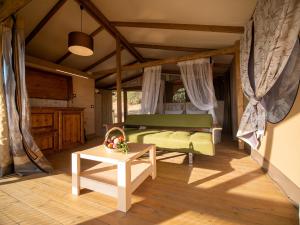 マッサ・マリッティマにあるGlamping Podere San Jacopoのベッドルーム(緑のベッド1台、テーブル付)
