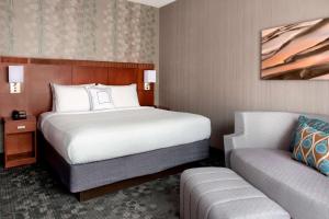 a hotel room with a bed and a couch at Sonesta Select Whippany Hanover in Whippany