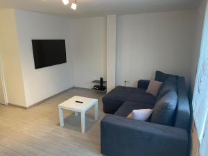 a living room with a blue couch and a table at Haberstraße 4b, Neumünser in Neumünster