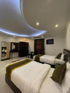 a hotel room with two beds and a circular ceiling at Arrawiya Alzahabia Hotel in Dammam