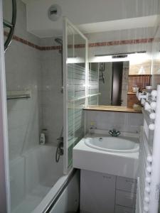 a bathroom with a tub and a sink and a shower at Appartement Pornic vue mer in Pornic