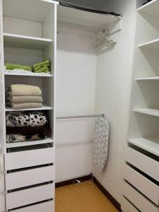 リマにあるLovely two bedroom apartment in Mirafloresのウォークインクローゼット(白い棚、タオル付)
